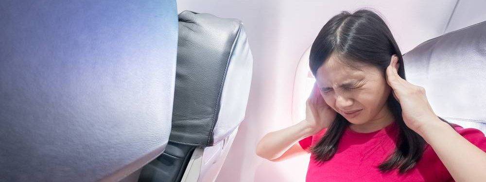 Vrouw met oorpijn op het vliegtuig
